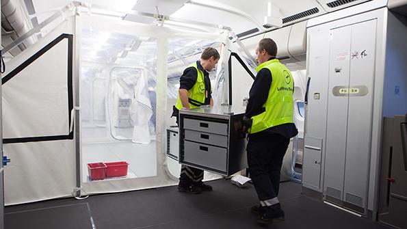 workers moving equipment in aircraft tent