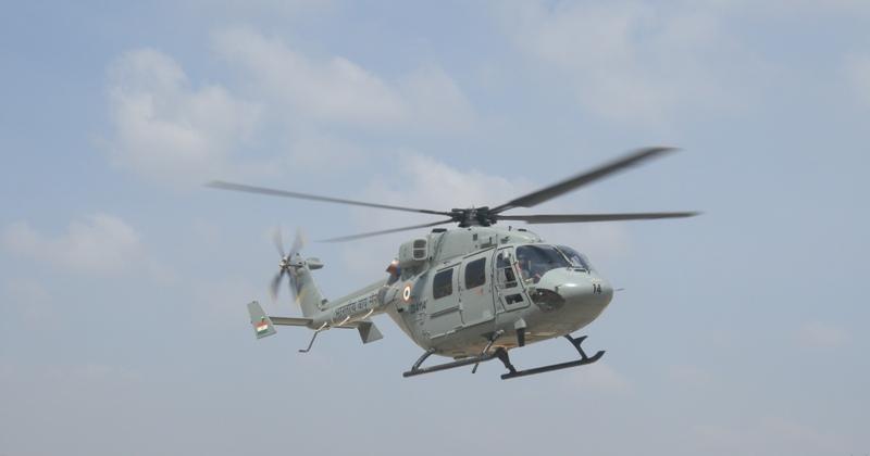 A Dhruv helicopter in flight viewed from the ground.