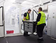 workers moving equipment in aircraft tent